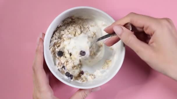 Nainen kädet sekoita lusikka kaurapuuroa jogurtti - Materiaali, video