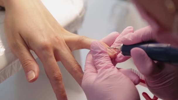 Manicurista taglia unghie con una macchina per un cliente in un salone di manicure. - Filmati, video