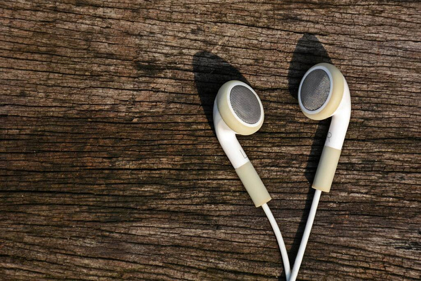 white earphones on old wood background - Photo, Image