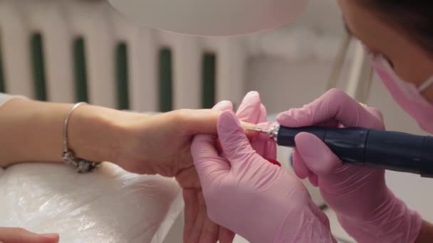 Manicure knipt nagels met een machine naar een klant in een manicure salon. - Video