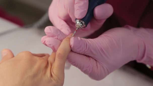 Manicure knipt nagels met een machine naar een klant in een manicure salon. - Video