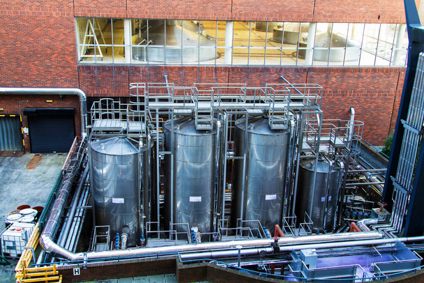 Fábrica de cerveza Guinness, Dublín, Irlanda - recipientes de fermentación y tubos de una fábrica de cerveza
. - Foto, imagen