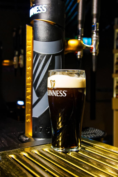 DUBLINO, IRLANDA - 11 NOV 2013: Pinta di birra servita al Guinness Brewery l '11 novembre 2013 a Dublino. Birreria dove 2,5 milioni di pinte di stout sono prodotte ogni giorno è stata fondata da Arthur Guinness nel 1759 - Foto, immagini