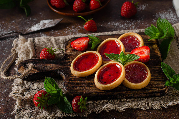 Delicious crispy tartlets with fresh strowberries jam and mint - Foto, Imagen