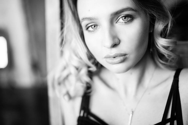 Close up monochrome portrait of curly blond charming woman. - Photo, image