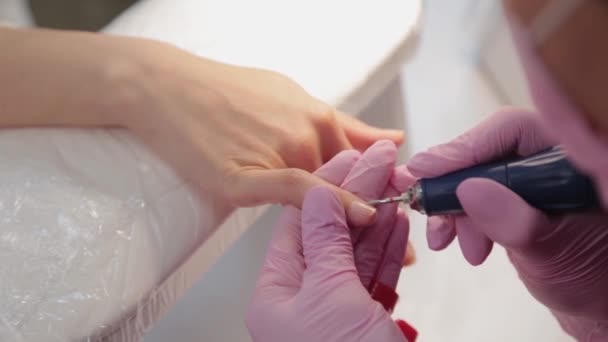 Manicurista taglia unghie con una macchina per un cliente in un salone di manicure. - Filmati, video