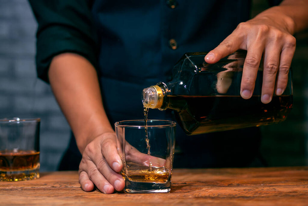 Barman pouring whiskey whiskey glass beautiful night - Zdjęcie, obraz