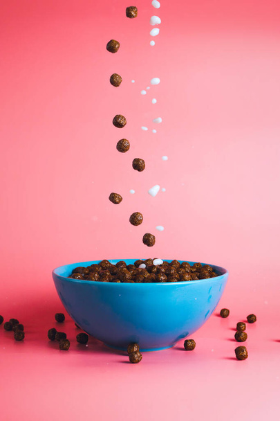 Chocolate breakfast cereals and plant milk poured into the bowl, concept of breakfast and morning, selective focus, dynamic picture - Zdjęcie, obraz