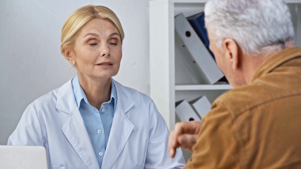 selective focus of mature doctor looking at man touching back  - Footage, Video