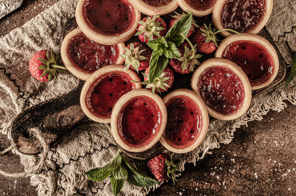 Delicious crispy tartlets with fresh strowberries jam and mint - Photo, Image