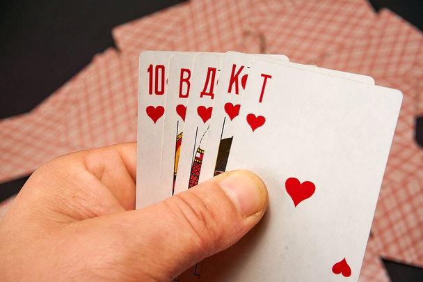 Pelikortit käsissä taustalla hajallaan käänteisiä kortteja - Valokuva, kuva