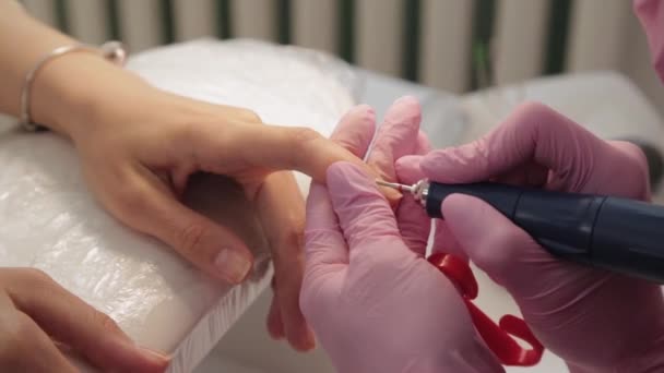 Manicurist cuts nails with a machine to a client in a manicure salon. - Footage, Video