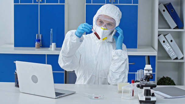 cientista falando no smartphone perto do laptop em laboratório
 - Filmagem, Vídeo