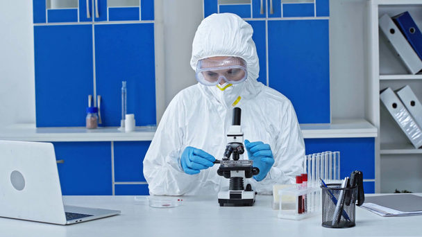 scientist holding sample and looking through microscope  - Filmmaterial, Video
