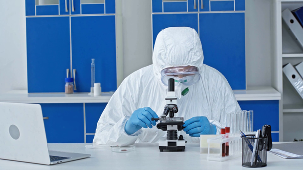 scientist holding sample while looking through microscope  - Metraje, vídeo