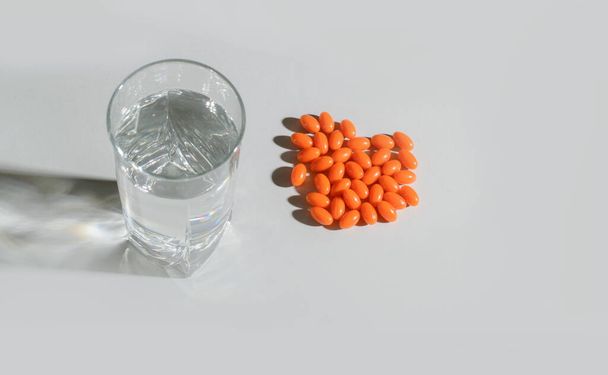 Um copo de água limpa com vitaminas naturais, com sombras sobre um fundo claro. Vista de cima. Serviços de saúde
 - Foto, Imagem