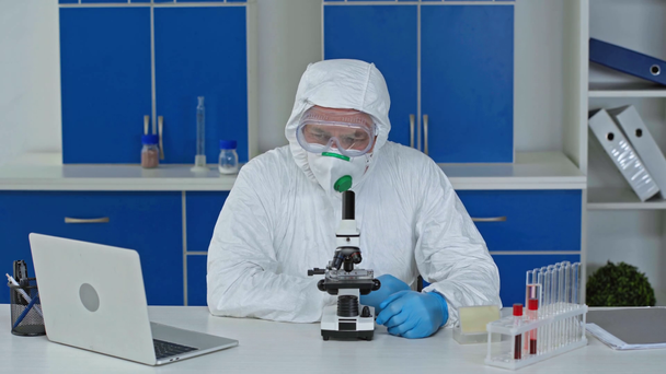 Verärgerter Wissenschaftler schaut durchs Mikroskop und gestikuliert im Labor - Filmmaterial, Video