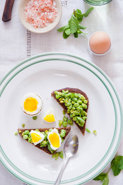 Bruschetta with green peas, mint and egg - Foto, afbeelding