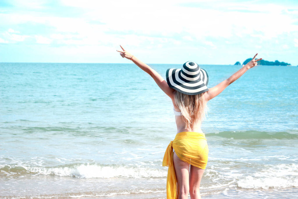 Szczęśliwego wakacyjnego wypoczynku, gorących seksownych, pięknych blondynek w białym bikini i kapeluszu z żółtym szalem bawiących się na plaży, odpoczywających i spędzających czas na relaksie na tropikalnej wyspie z błękitnym morzem - Zdjęcie, obraz