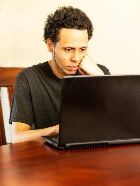 Hombre usando portátil en casa. Hombre usando tecnología. Hombre sentado en el comedor usando laptop. Hombre mirando la pantalla del ordenador portátil
. - Foto, Imagen
