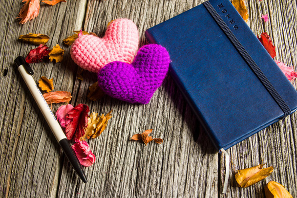 фиолетовое сердце и записная книжка с ручкой на фоне старого дерева
 - Фото, изображение