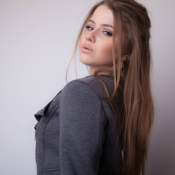 Young beautiful stylish girl posing in studio. - Фото, изображение