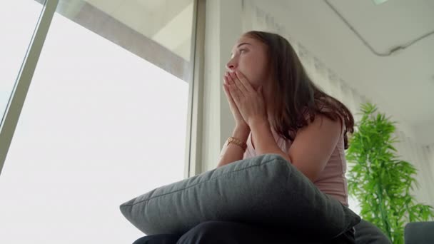 duševní zdraví, žena sedí ve stresu u okna, v epidemickém stavu covid -19, což způsobí, že ztratí práci - Záběry, video