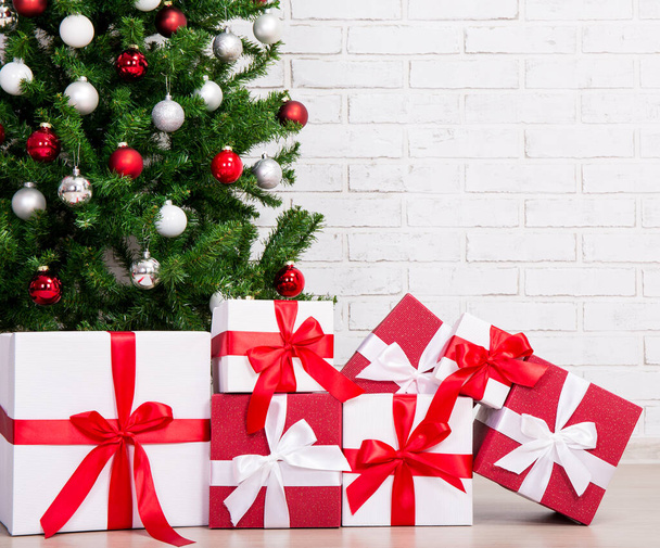 Cajas de regalo bajo el árbol de Navidad decorado con bolas de colores
 - Foto, imagen