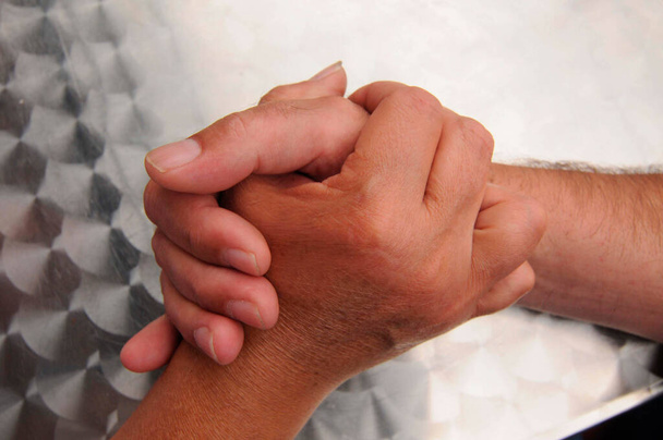 dwie osoby trzymające się za ręce, symbol zażyłości i sympatii - Zdjęcie, obraz