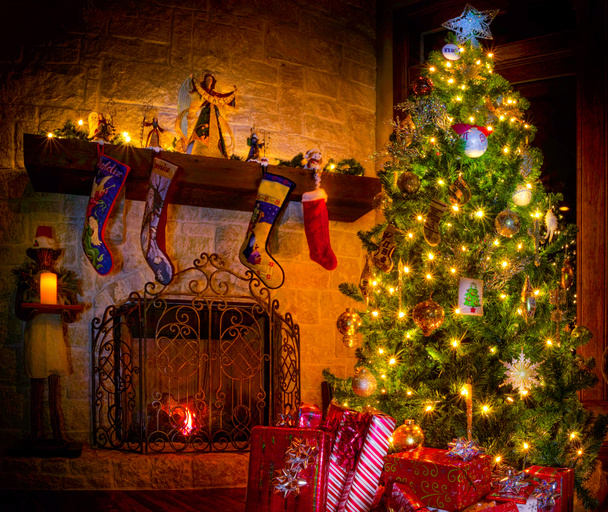 Уютная рождественская сцена с камином, подарками и украшенной елкой
 - Фото, изображение