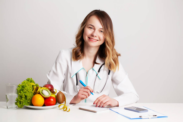 Nutritionist makes a diet plan for proper nutrition for the patient in his office - Photo, Image