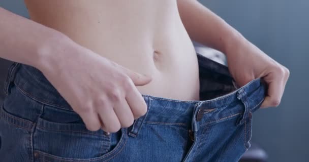 Fille mince portant un pantalon en denim large, résultat de perte de poids - Séquence, vidéo