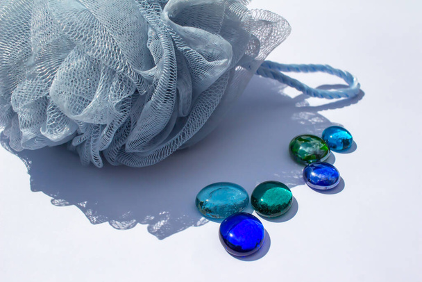 Közelkép elvont kilátás színes sárkány könnyek és egy kék háló fürdő szivacs fehér háttér - Fotó, kép