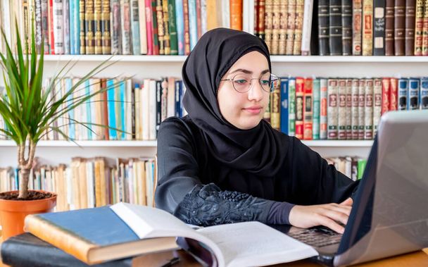 Arabska muzułmanka używająca laptopa do spotkań online i nauki - Zdjęcie, obraz