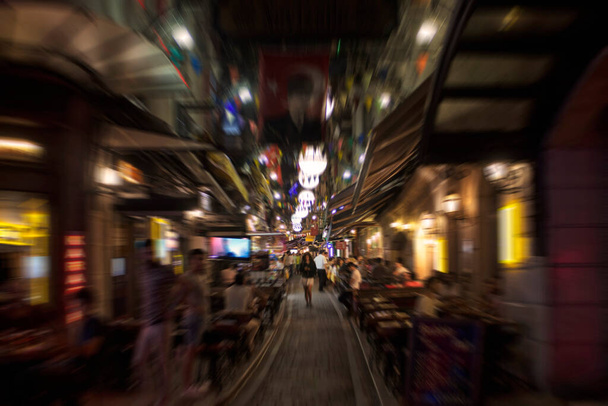 Blurry motion image of people walking on a street in Taksim /Beyoglu area at night in Istanbul. Location is a busy nightlife, shopping and dining district. - Foto, afbeelding