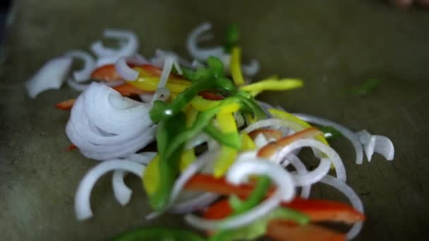Sekání zeleniny, cibule, papriky a papriky na řezací desce. - Záběry, video