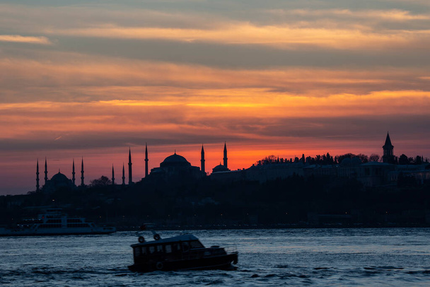 Puesta de sol sobre la Mezquita Azul con Santa Sofía en silueta en el Bósforo Estambul
. - Foto, Imagen