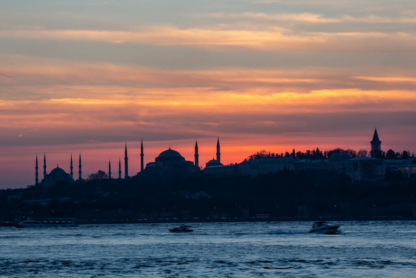 Sonnenuntergang über der Blauen Moschee mit Hagia Sophia in der Silhouette am Bosporus Istanbul. - Foto, Bild