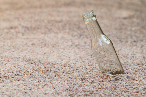 Empty glass bottles on the sand Concept of garbage pollution - Foto, imagen