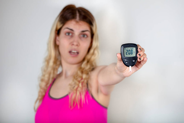Measuring of blood sugar for diabetes patient. Pretty lady measuring diabetes. - Photo, Image
