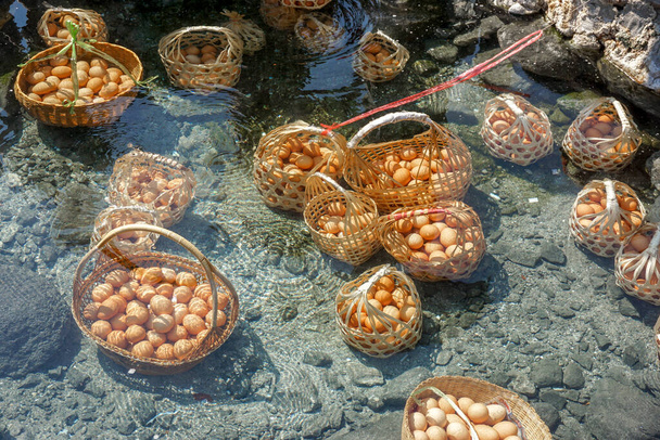 Closeup a plodiny kuřecí vejce v košíku turistů vařené v minerální a přírodní teplé vody v Chae Son National Park, Lampang, Thajsko. - Fotografie, Obrázek