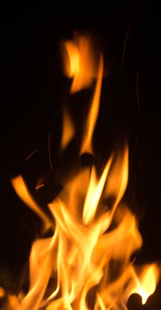 Vuur vlammen met vonken op zwarte achtergrond - Foto, afbeelding