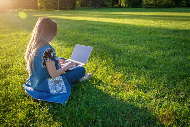 Venku pracuje žena přes internet. Notebook, počítačová technologie. Studentka pracující na tabletu v letním přírodním parku. Lidé venku. Utekl z konceptu kancelářské distanční vzdělávání - Fotografie, Obrázek