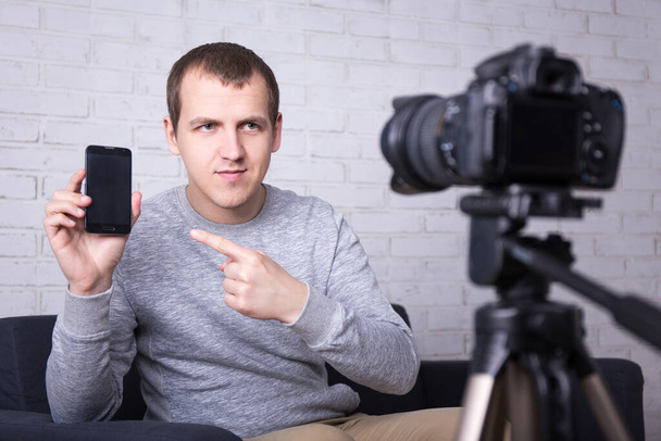 jeune blogueur vidéo faisant une nouvelle vidéo sur les téléphones intelligents - Photo, image