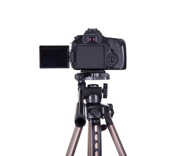koncept fotografie a videografie - zadní pohled na moderní dslr kameru s prázdnou obrazovkou na stativu izolované na bílém pozadí - Fotografie, Obrázek