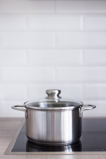 close up of metal pot on electric stove in modern kitchen - Φωτογραφία, εικόνα