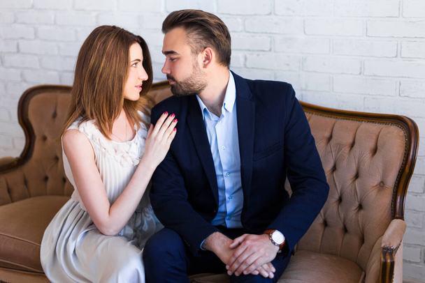 relacja i koncepcja miłości - portret młodej pięknej pary siedzącej i całującej się na zabytkowej sofie - Zdjęcie, obraz