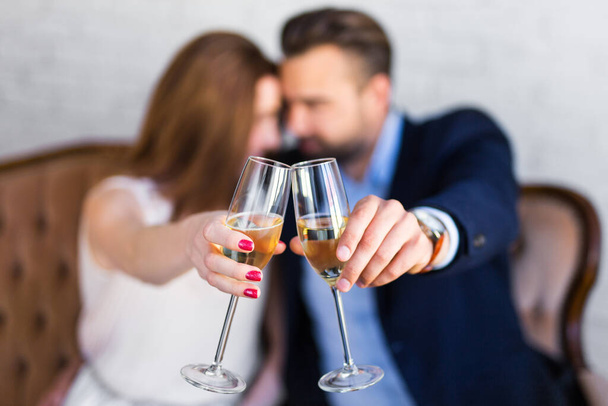 happy young couple with glasses of champagne sitting at restaurant - Photo, Image
