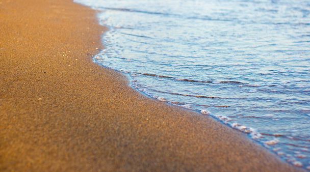 κοντινή απόσταση από αμμώδη παραλία με χρυσή άμμο στο ηλιοβασίλεμα - Φωτογραφία, εικόνα