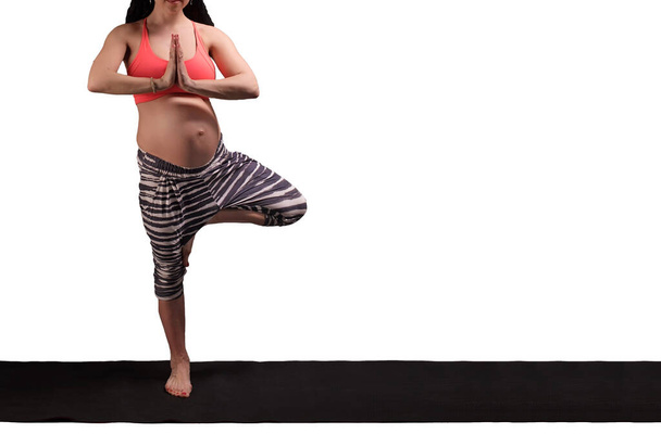 Mujeres deportistas embarazadas flexibles en equilibrio de yoga posan sobre fondo blanco aislado. Concepto de maternidad relajante y meditante y saludable. Estilo de vida activo
 - Foto, imagen